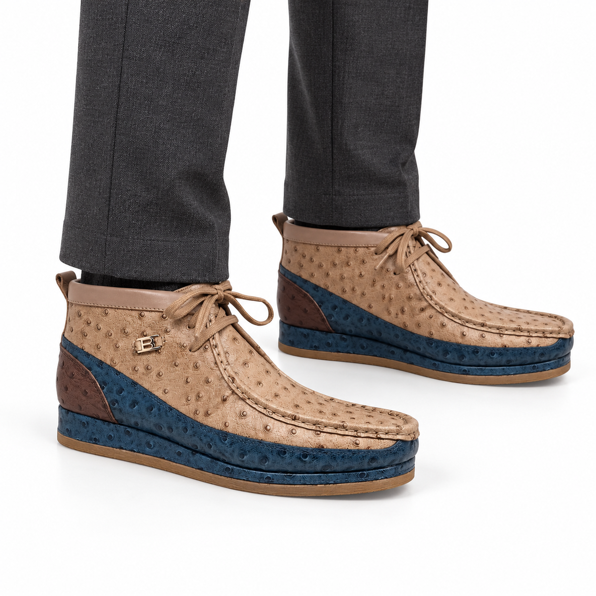 AI-generated on-model view of New Castle Cognac/Navy ostrich-print leather chukka boots with charcoal trousers on a white background.