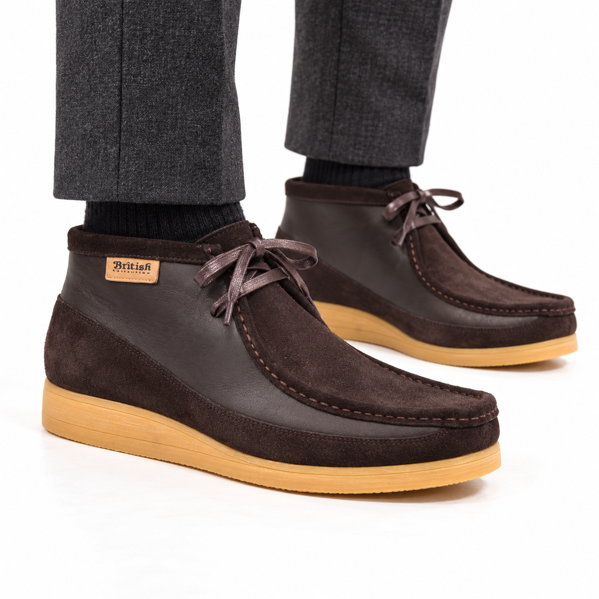 AI-generated on-model styling view of British Walkers New Castle Brown suede and leather ankle boots, worn with charcoal trousers on a white studio background.