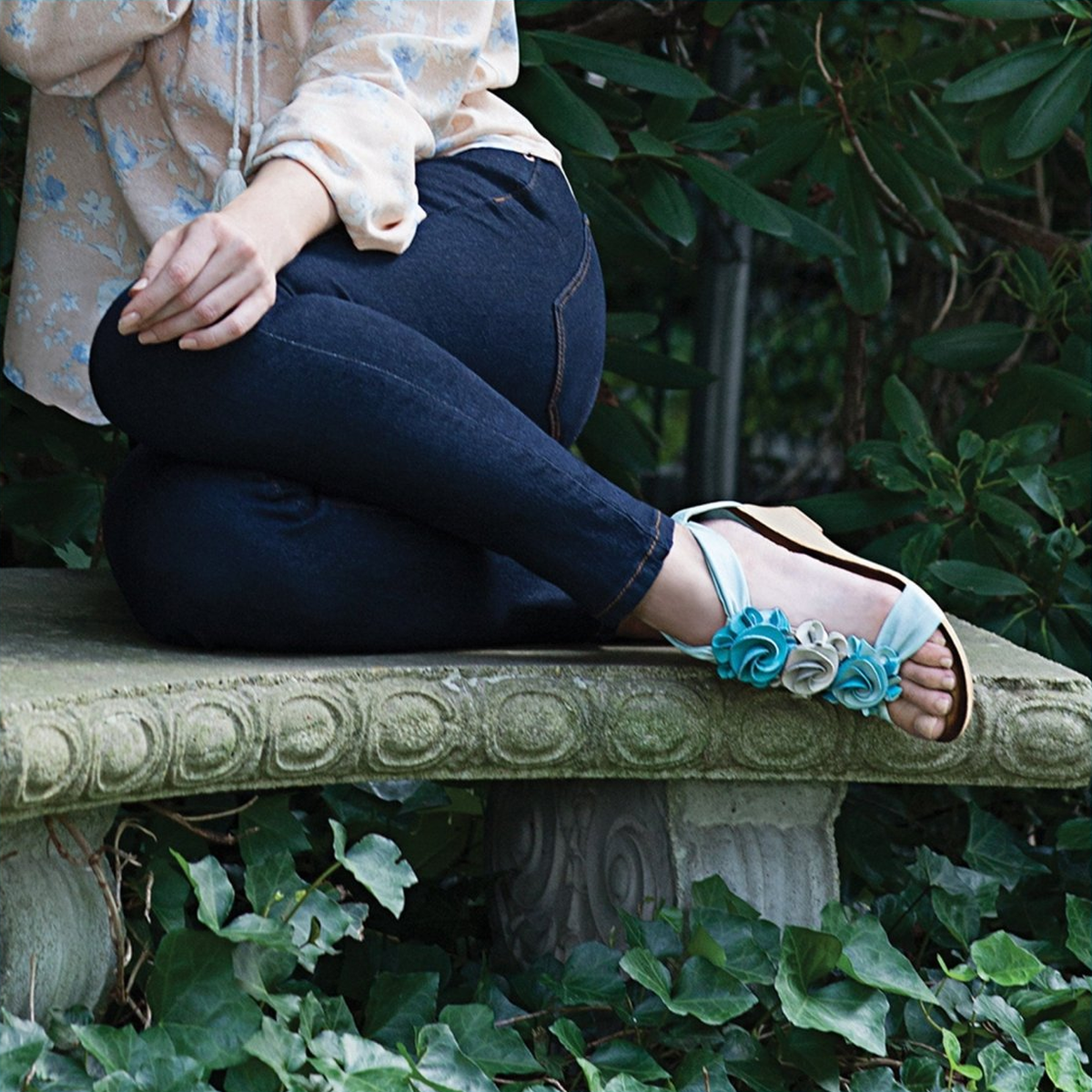 Patrizia Harlequin Multi sandal in Aqua Multi worn while seated on a garden bench