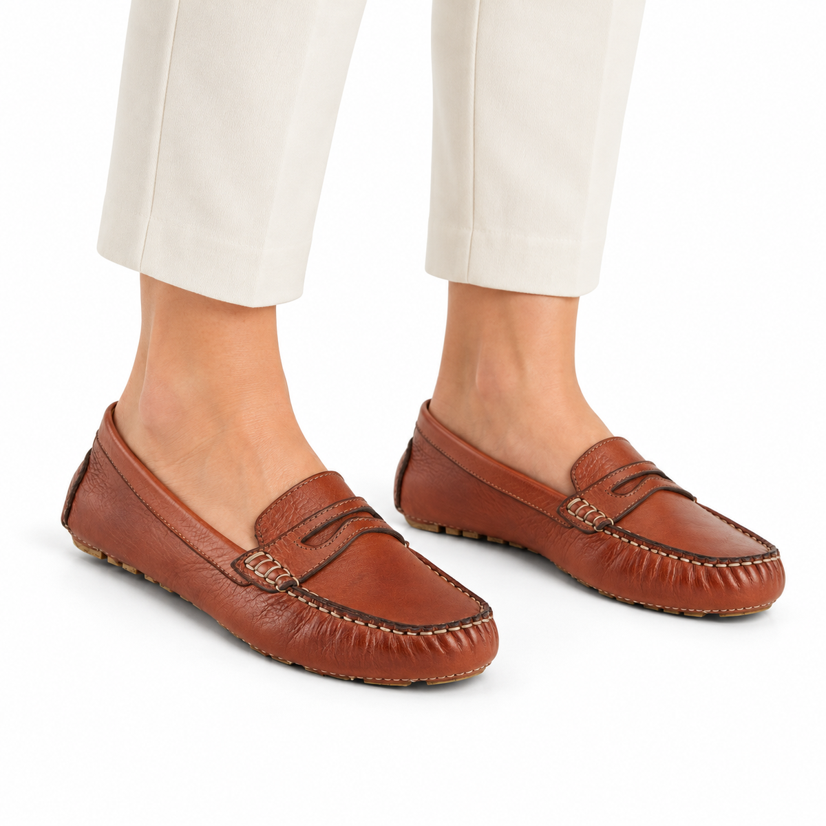AI-generated styling illustration of Spring Step Audette penny loafers in Brown, worn with ivory cropped trousers on a white background.
