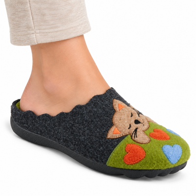AI-generated on-model styling illustration of the Flexus Cuttlecat Green/Multi slipper with cat and heart appliques, worn on a white studio background.