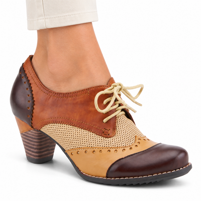 AI-generated on-model view of the L'Artiste Bardot Brown lace-up heeled shoe with cognac, dark chocolate, tan and perforated beige panels on a white studio background.