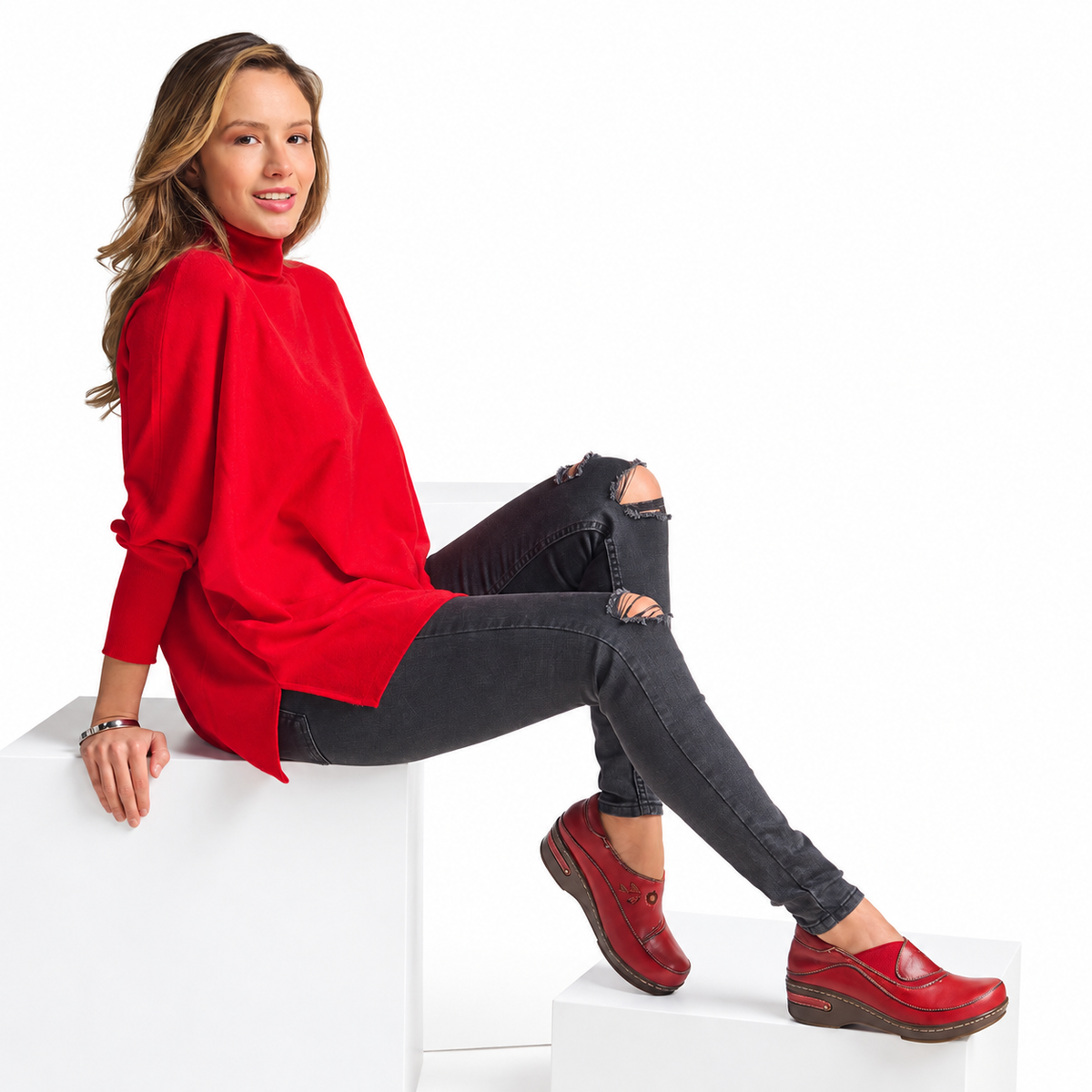 L'Artiste Burbank in Red, seated model on white blocks; AI-assisted white-background styling edit