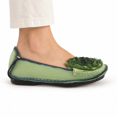 L'Artiste Dezi Green flat, on-foot side view against white; AI-generated styling illustration