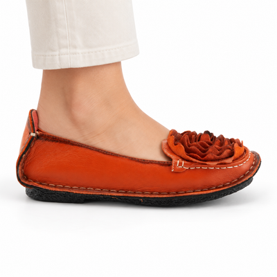 L'Artiste Dezi Orange flat, on-foot side view against white; AI-generated styling illustration