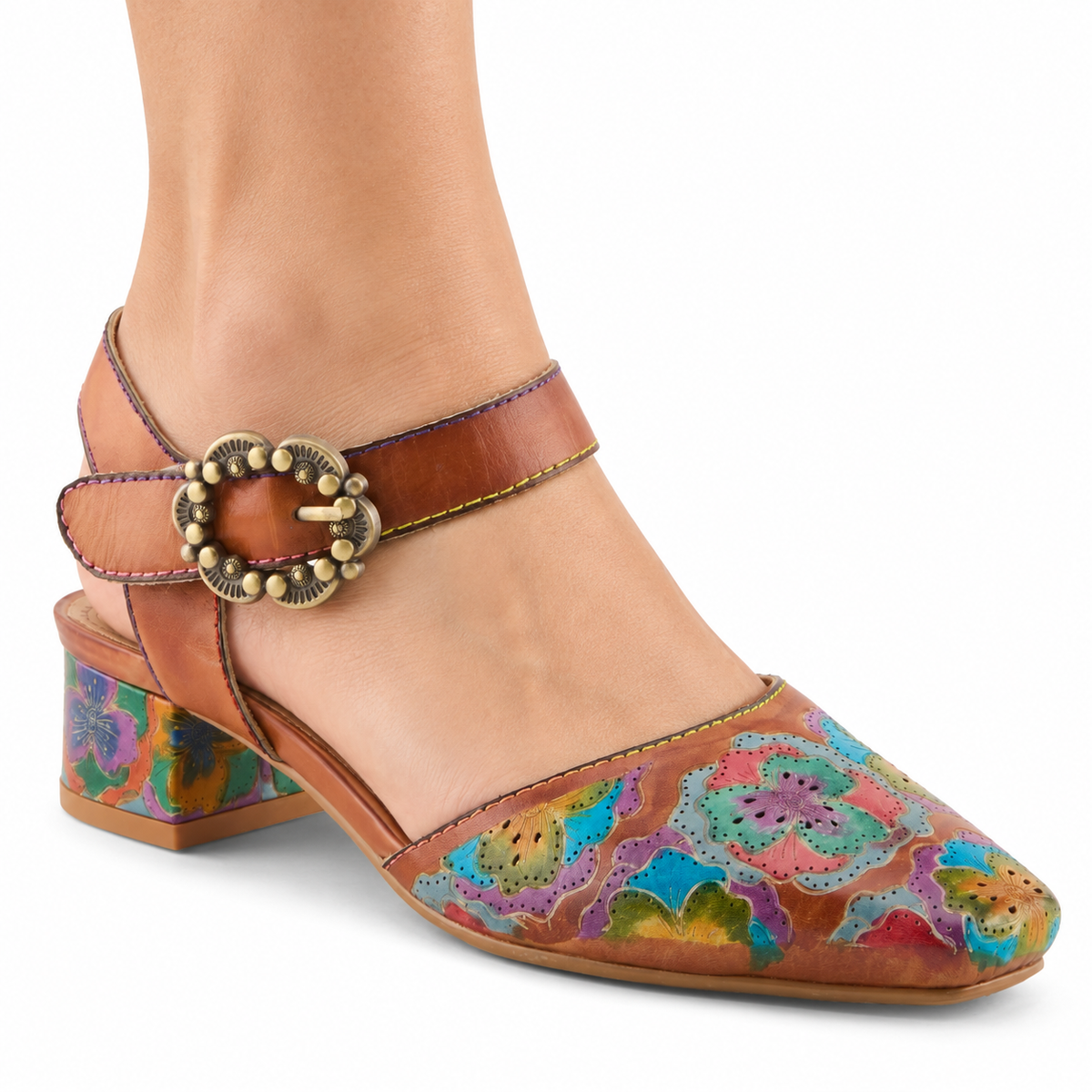 AI-generated on-model view of L'Artiste Funferbiz Camel Multi: one woman's lower leg wearing the floral closed-toe shoe with camel ankle straps, an antique-brass scalloped buckle and a low floral block heel on a white background.
