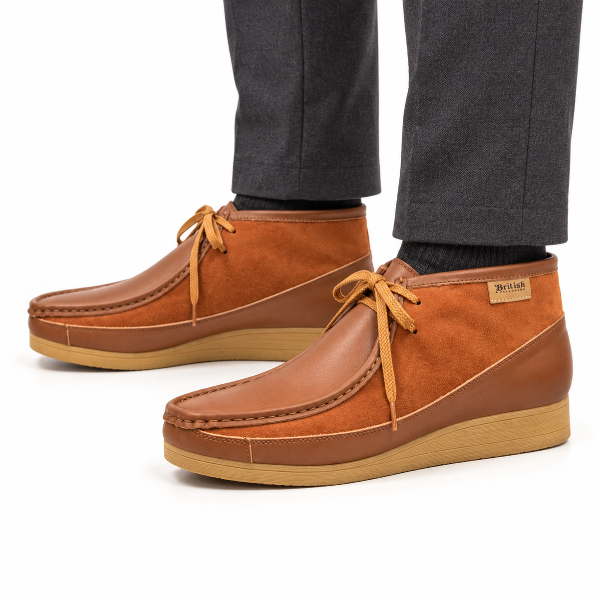 AI-generated on-model view of British Walkers New Castle Classic Cognac/Tan leather-and-suede ankle boots with charcoal trousers on a white background.