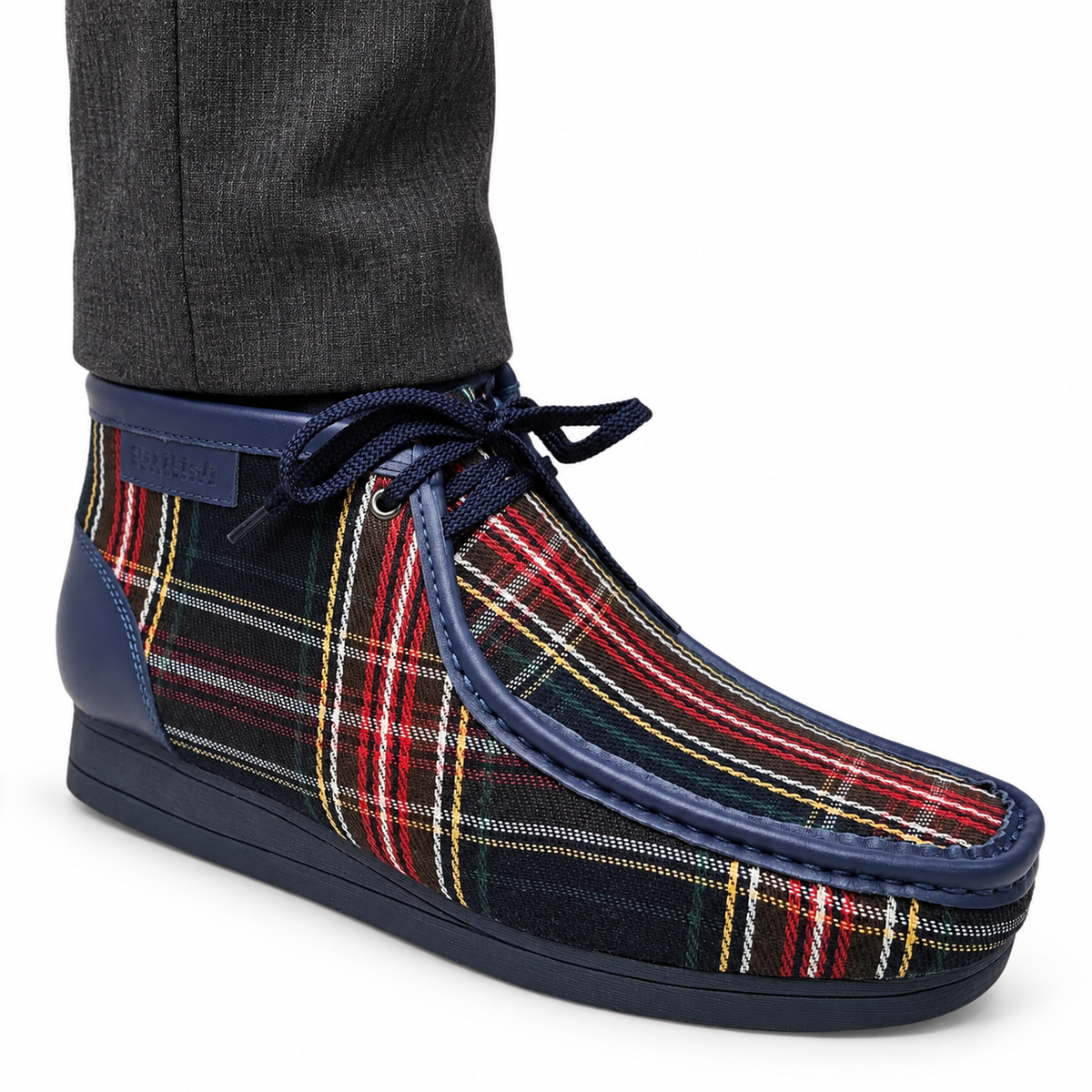 AI-generated on-model styling view of a British Walkers New Castle Limited Plaid Navy Multi Plaid ankle boot, worn with charcoal trousers on a white studio background.