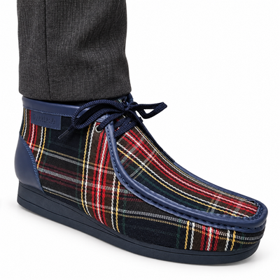 AI-generated on-model styling view of a British Walkers New Castle Limited Plaid Navy Multi Plaid ankle boot, worn with charcoal trousers on a white studio background.