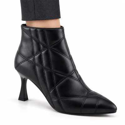 AI-generated on-model styling illustration of a Patrizia Theana black ankle boot, worn with charcoal trousers on a white studio background. Fine quilted stitching and surface details are generative and may differ from the authentic product photos.