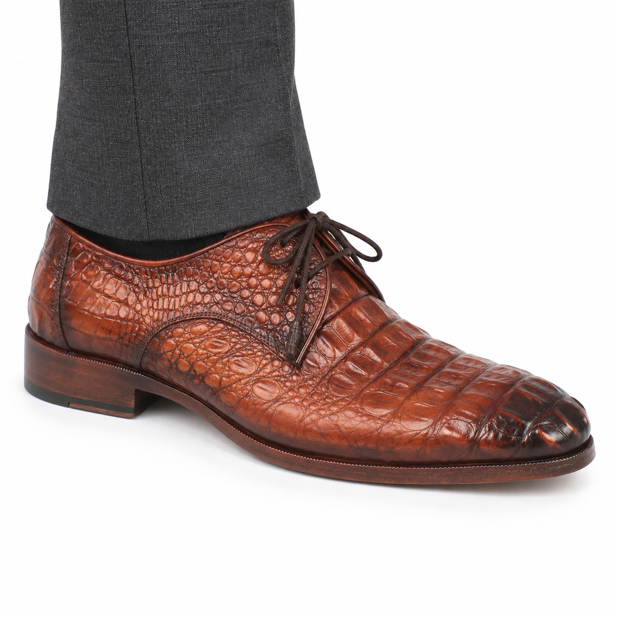AI-generated on-model styling illustration of a Paul Parkman 1438TAB light-brown crocodile-embossed calfskin derby shoe, worn with charcoal trousers on a white studio background. Fine embossed details are generative and may differ from the authentic product photos.