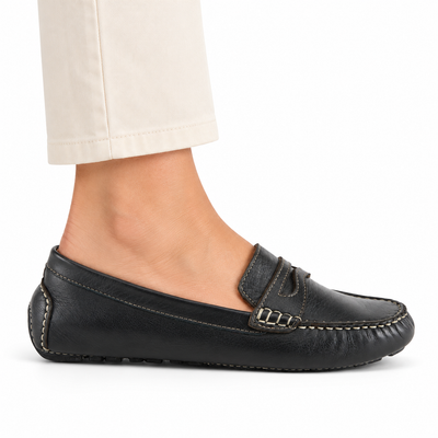 Spring Step Audette penny loafer in Black, side view on foot against white; AI-generated styling illustration